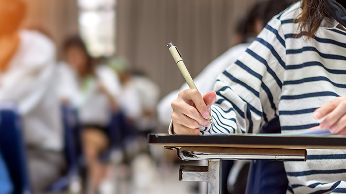 Students are working in an exam hall. 