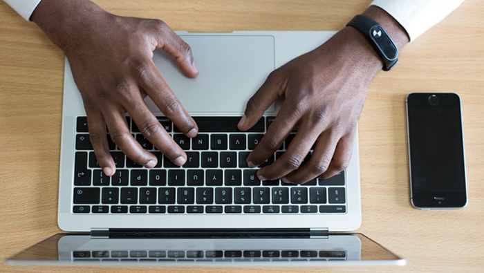 Generic image of hands on a laptop keyboard.