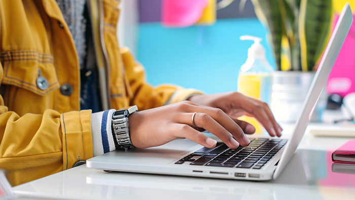 A student in colourful clothes using a laptop