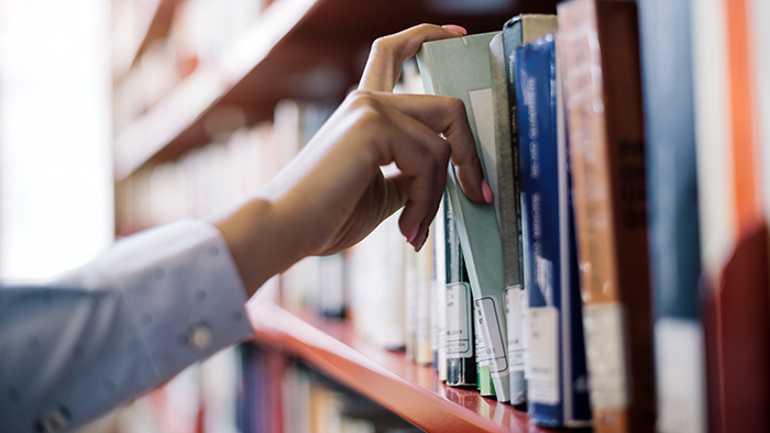 Person pulling out a book