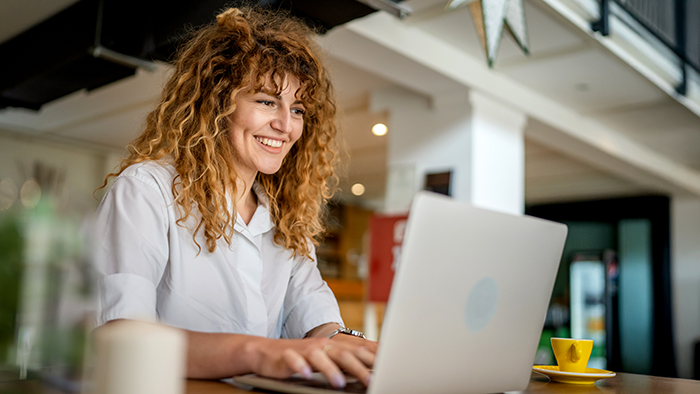 A cheerful student working on a laptop.