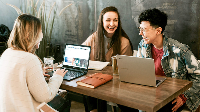 Three students cheerfully working together.