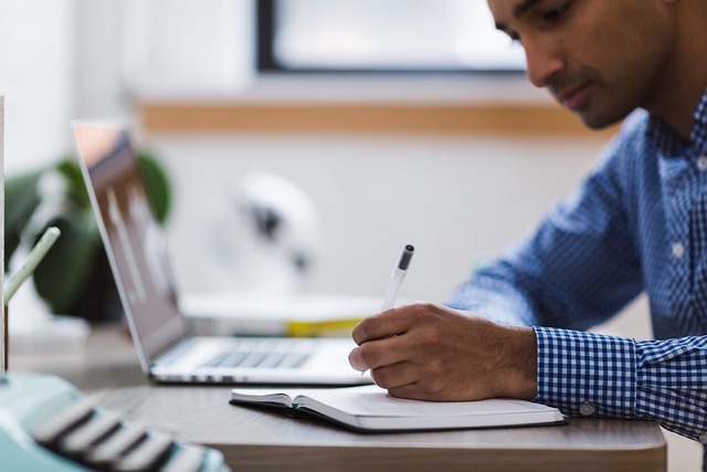 Image of a man using laptop to review research