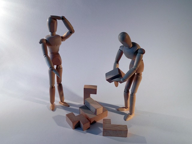 Image of 3 wooden artists manequins solving a problem together