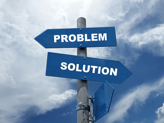 An image of a signpost with the words problem and solution written on blue arrows pointing in opposite directions