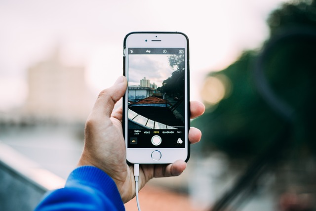 Image of someone holding a mobile phone taking a photo of the city