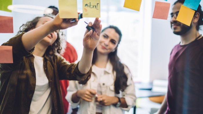 Students sticking stick notes on board