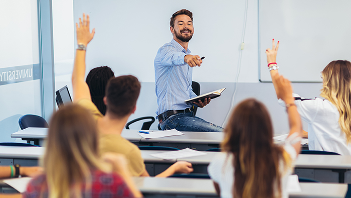 Students in a classroom eagerly raising their hands