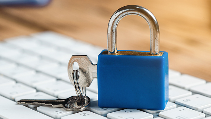 A padlock resting on a computer keyboard.
