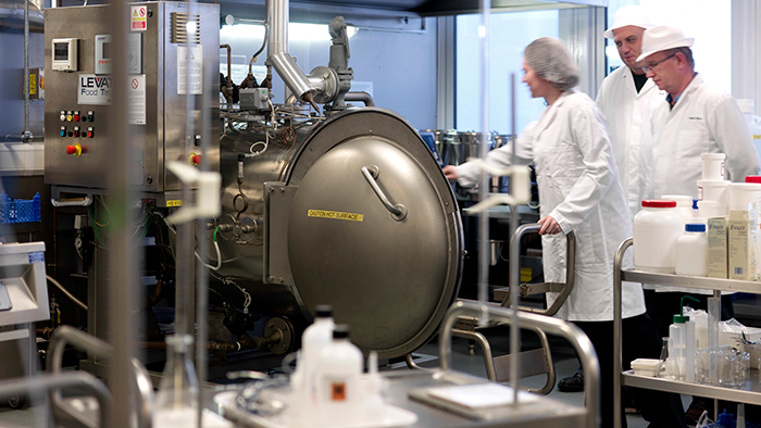 Some Hallam staff in chef's whites, inspecting technical equipment in Owen Kitchen. 