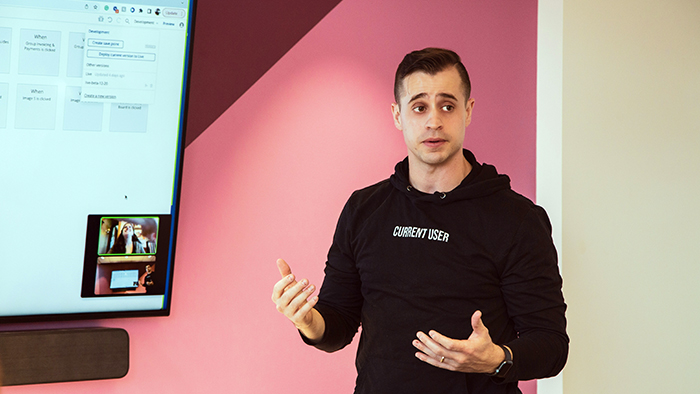 A young male teacher passionately explaining something to a classroom.